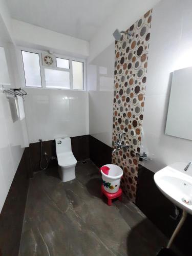a bathroom with a toilet and a sink at Hosamane Farm Inn in Sringeri