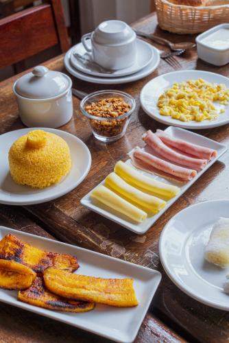 a wooden table with plates of food on it at Pousada Mandala do Vale in Vale do Capao