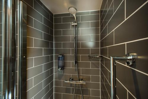 a shower with a shower head in a bathroom at Holiday Inn Express Burton on Trent by IHG in Burton upon Trent