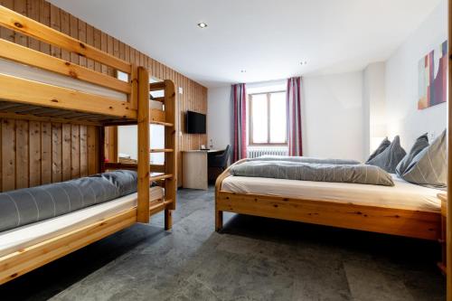 a bedroom with two bunk beds and a desk at Hotel Bellevue in San Bernardino