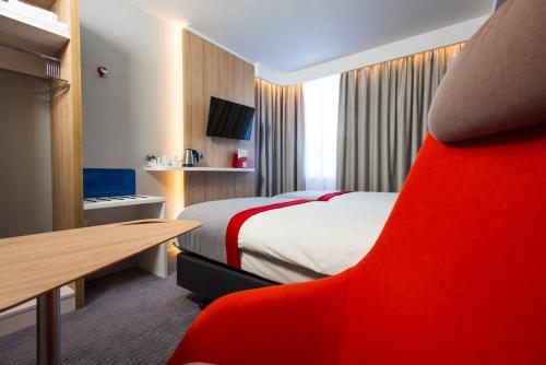 a hotel room with a bed and a red chair at Holiday Inn Express Burton on Trent by IHG in Burton upon Trent