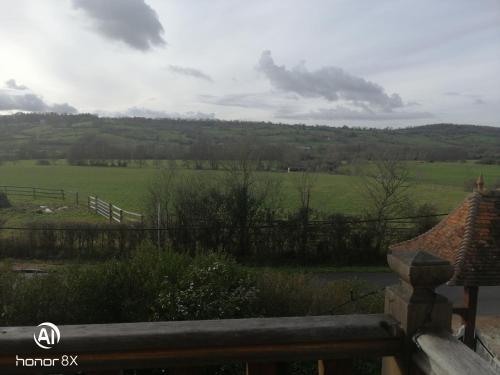 uma vista para um campo a partir do alpendre de uma casa em Lieu Baudouin em Livarot