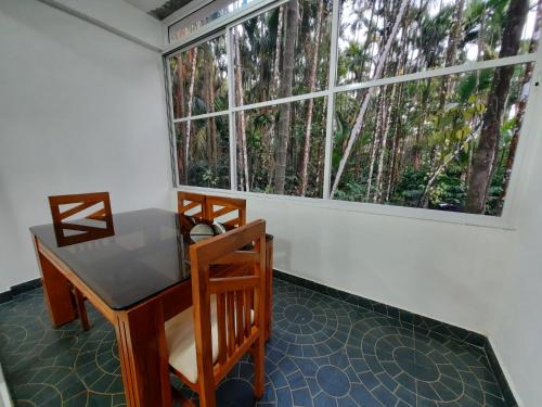 a room with a table and chairs and a window at Hosamane Farm Inn in Sringeri