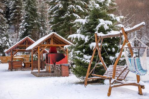 a playground in the snow with a swing at Casa Danielle in Topliţa