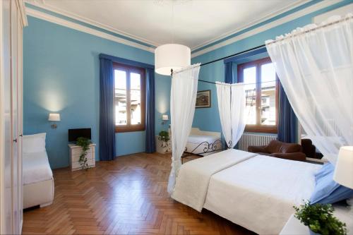 ein Schlafzimmer mit einem weißen Bett und blauen Wänden in der Unterkunft Hotel Jolì in Florenz