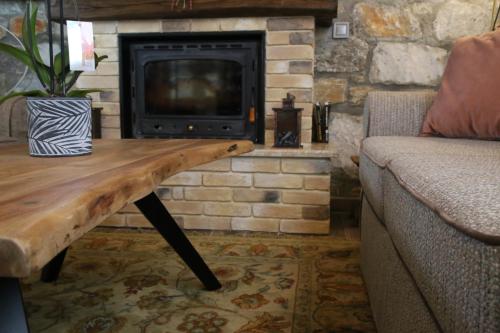 a living room with a wooden table in front of a fireplace at Petrines Villes Avramilias in Avramiliá