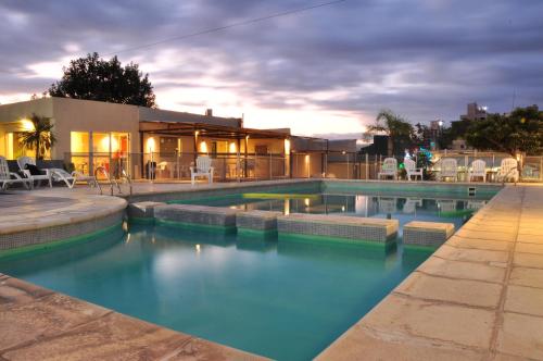 a swimming pool with blue water in front of a house at Hotel Linz in Villa Carlos Paz