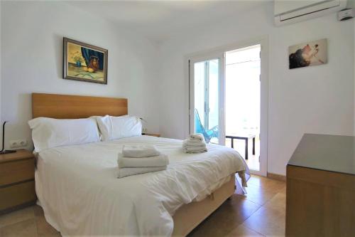 una camera da letto con un grande letto bianco con asciugamani di Apartment PP11 a Estepona