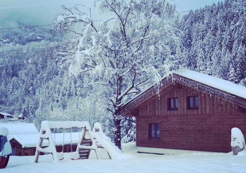 a log cabin with snow on the roof of it at Feriendorf X-Alp Lodges Ötztal in Sautens