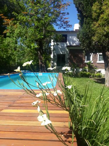 un patio con piscina y flores en una terraza de madera en La Marea B&B en Tigre