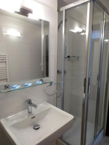 a bathroom with a sink and a shower at Zámecký Hotel ANTON FLORIAN in Valtice