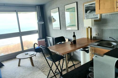 Una cocina con una mesa y sillas y un fregadero. en Victoria Surf Biarritz 102, en Biarritz