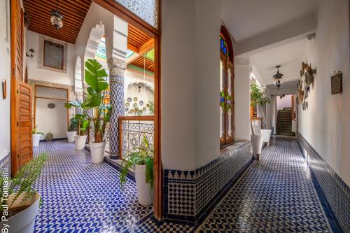 a hallway with a bunch of potted plants at Riad Fes Nass Zmane in Fès