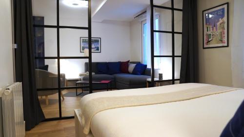 a bedroom with a bed and a living room at Appartements Les Rochelais in La Rochelle