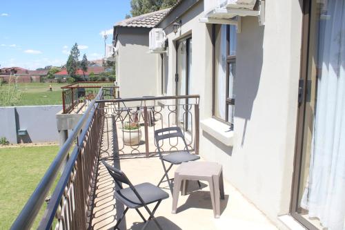 two chairs and a table on a balcony at The Anne Guest House in Maseru