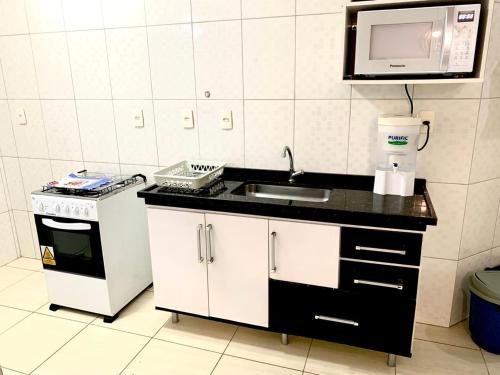 a kitchen with a sink and a microwave at Apartamento Itagua Acaraú in Ubatuba