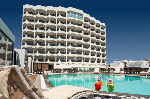 a hotel with a swimming pool with a large building at Concorde Sfax Centre in Sfax