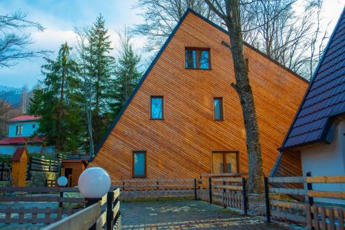 duży drewniany dom ze spiczastym dachem w obiekcie Meshtekna w mieście Brezovica
