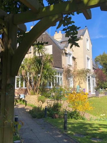 a house with a dog laying in the yard at Bedford Lodge in Shanklin