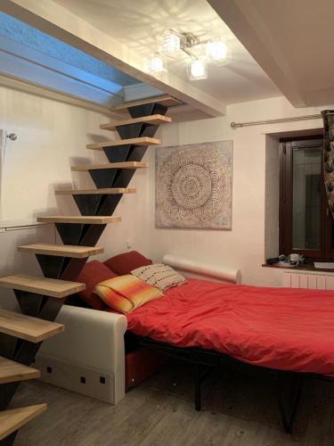 a bedroom with a bed and a spiral staircase at Lac et Montagne in Anthy
