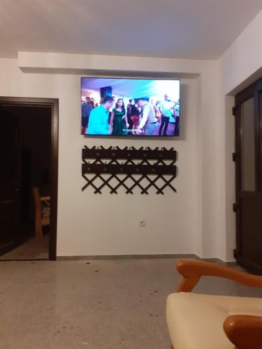 a flat screen tv on a wall in a living room at Pensiunea Natura Sadu in Sibiu