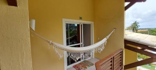 a hammock hanging on the side of a house at Aldeia St Sebastien 31 Arembepe in Arembepe