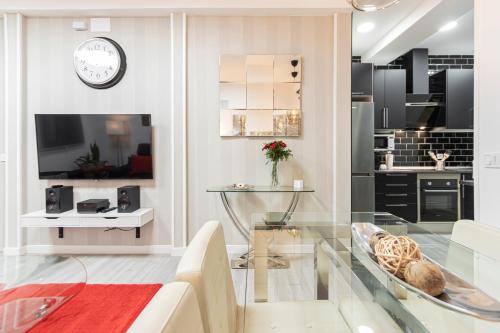 a living room with a glass table and a kitchen at Madrid Rio Apartment in Madrid