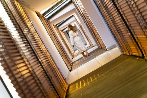 a woman in a white dress looking out of a window at Concorde Sfax Centre in Sfax