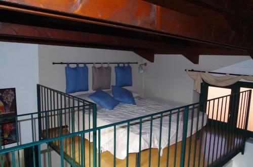 een kamer met een bed met blauwe kussens en een balkon bij LA CASETTA in Biella