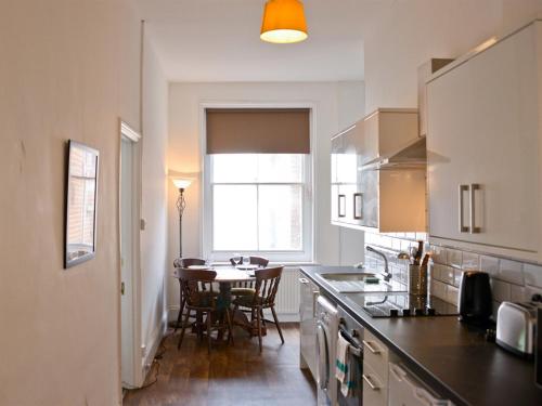 a kitchen with a table and a dining room at Corner House apartment in Worthing