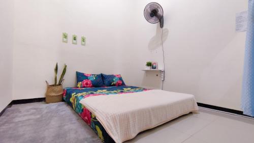 Schlafzimmer mit einem Bett und einem Ventilator in der Unterkunft Surabaya Homey near ITS in Surabaya