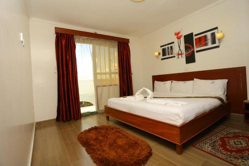 a bedroom with a large bed and a window at Merril Hotel in Eldoret