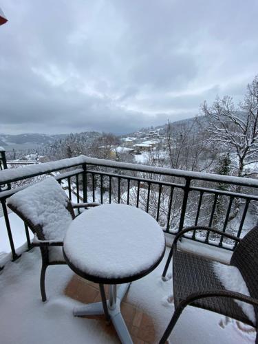 a balcony with a table and chairs covered in snow at Nefeles in Neochori