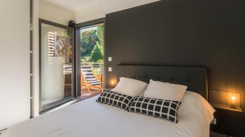 a bedroom with a bed and a large window at Villa Sunshine avec Jacuzzi Privatif in Sarlat-la-Canéda