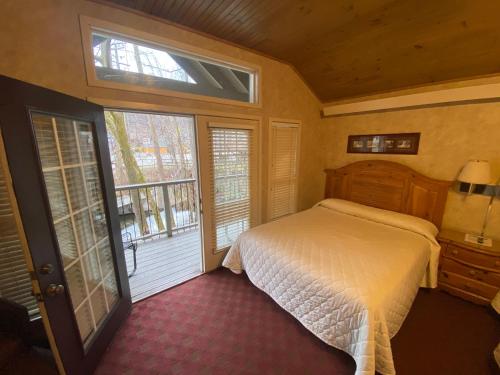 a bedroom with a bed and two windows at Carr's Northside Hotel and Cottages in Gatlinburg