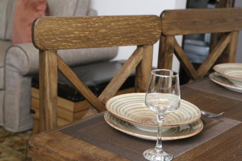 a table with plates and a wine glass on it at Petrines Villes Avramilias in Avramiliá