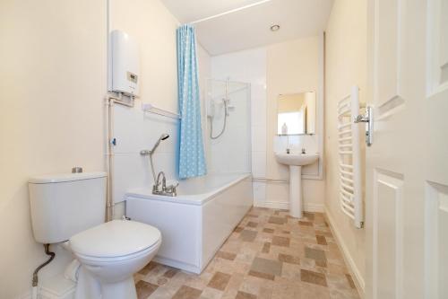 a white bathroom with a toilet and a sink at Becket apartment in Yeovil