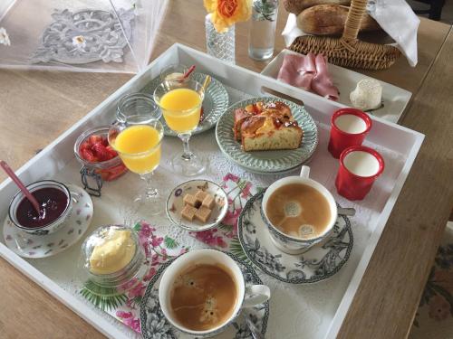 una bandeja de alimentos para el desayuno y bebidas en una mesa en La petite madeleine - Chambre d'hôtes & spa, en Burgy