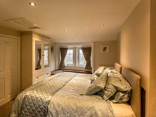 ein Schlafzimmer mit großem Bett und Fenster in der Unterkunft Owl Cottage in Keighley