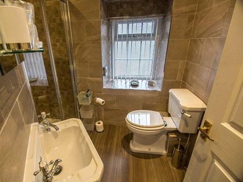 ein Badezimmer mit Toilette und Waschbecken und einem Fenster in der Unterkunft Owl Cottage in Keighley