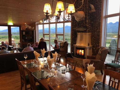 a dining room with a table and a fireplace at Eyjar Fishing Lodge in Breiðdalsvík