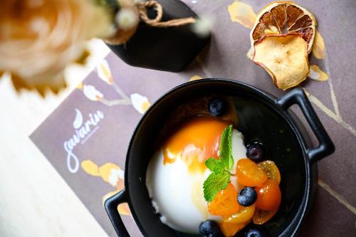 a bowl of food with fruit and eggs on a table at Hotel Bohemia in Bacău