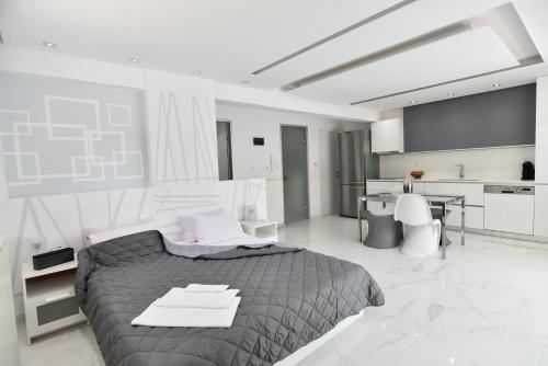 a bedroom with a large bed and a kitchen at Alpha Delta Pool Suite in Paleo Tsifliki