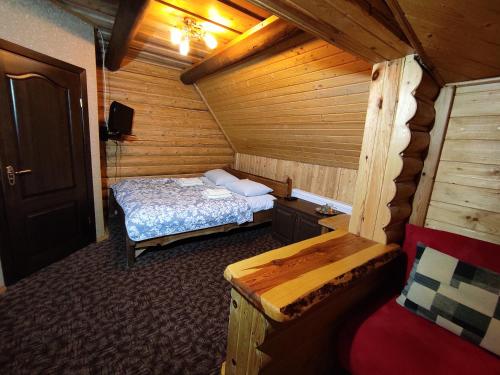 a room with a bed in a wooden cabin at Вотавілю Драгобрат in Dragobrat
