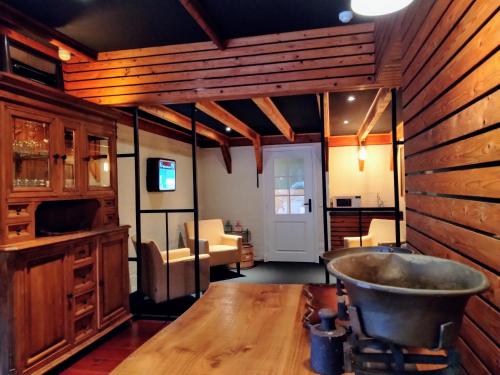 uma sala de estar com uma parede de madeira e uma banheira de metal em B&B Katoo em Linne