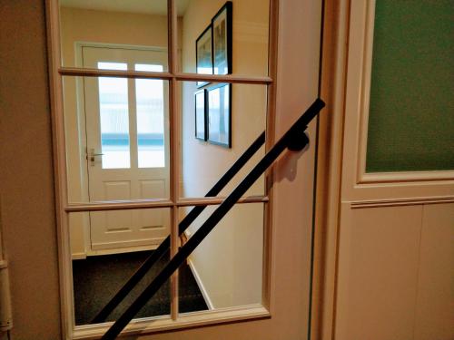 a door with a view of the ocean through a window at B&B Katoo in Linne