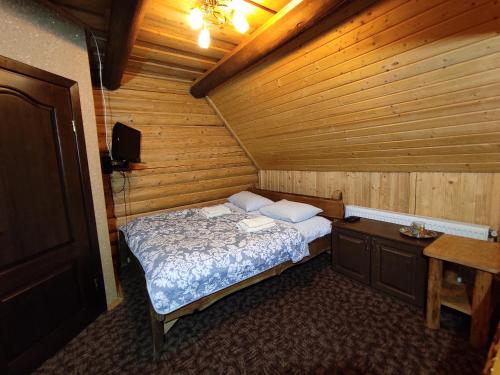 a bedroom with a bed in a wooden room at Вотавілю Драгобрат in Dragobrat