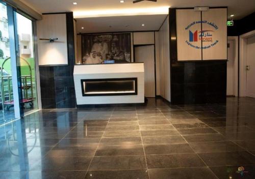 a lobby with a fireplace in the middle of a building at Manazeli Jeddah - in Jeddah