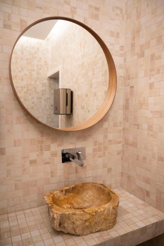 a bathroom with a large mirror and a stone tub at Hotel Bohemia in Bacău