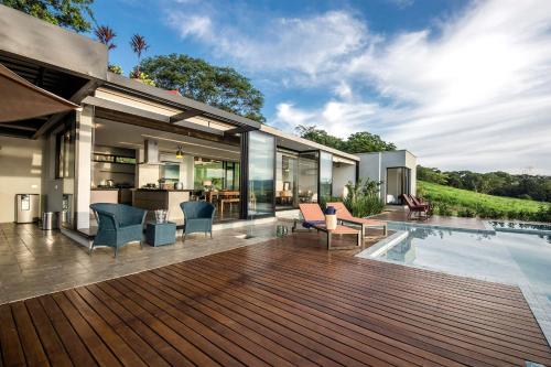 eine offene Terrasse mit einem Pool und einem Haus in der Unterkunft @morro.redondo - A casa no Lago e na Serra in CÃ¡ssia